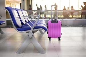 uma mala rosa no terminal de embarque no aeroporto foto