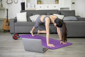 uma jovem mulher bonita está fazendo o exercício de alpinista em casa foto