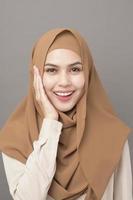 retrato de mulher bonita com hijab está sorrindo em fundo cinza foto