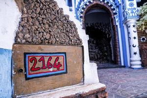 trilha com número da casa na prancha de madeira, abstrato ornamentado através da entrada em arco foto