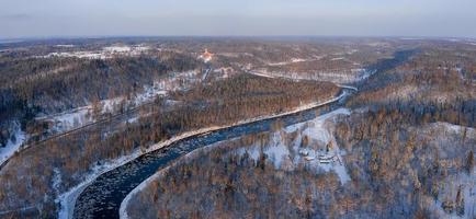 inverno em sigulda, letônia. rio gauja e castelo turaida ao fundo. foto