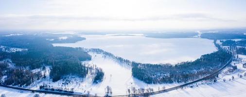 bela vista aérea do enorme lago congelado no meio de uma floresta na letônia. Lago Ungurs congelado na Letônia. foto