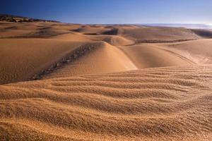 belas dunas de areia e céu dramático na praia durante o pôr do sol foto