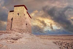 edifício de barro cercado por muros altos em terra deserta foto