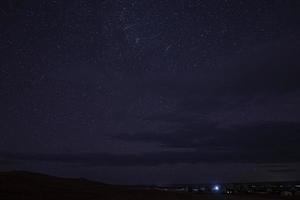 incrível vista do céu estrelado acima da paisagem do deserto durante a noite foto