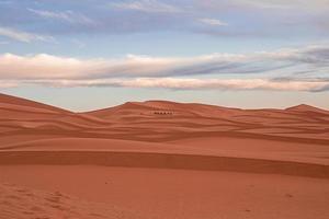 incrível vista de dunas de areia com padrão de ondas no deserto contra céu nublado foto