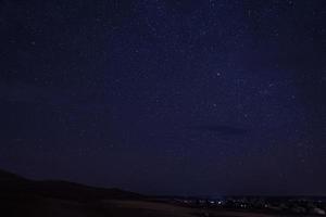 incrível vista do céu estrelado acima da paisagem do deserto durante a noite foto