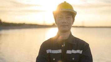 um engenheiro masculino usando um capacete protetor ao pôr do sol. foto