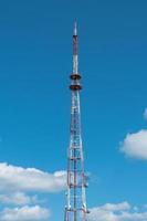 torre de telecomunicações com antenas no fundo do céu com nuvens foto