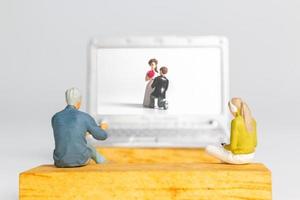 pessoas em miniatura noiva e noivo casamento virtual na tela do computador foto