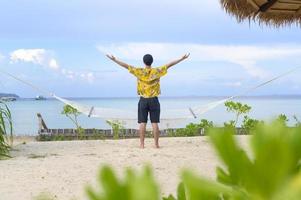 homem feliz curtindo e relaxando no conceito de praia, verão e férias foto