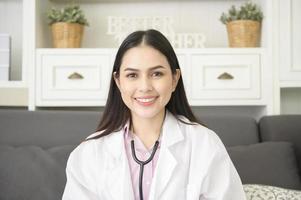 retrato de médica com estetoscópio no escritório e sorrindo para a câmera. foto