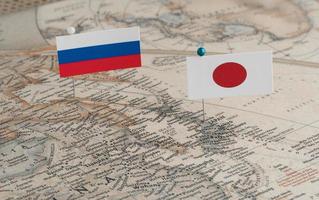 as bandeiras da rússia e do japão no mapa do mundo. fotografia conceitual, diferenças políticas devido à ilha de Sakhalin foto