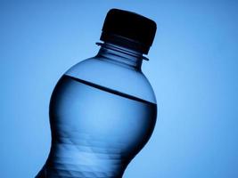 uma garrafa de água é isolada em um fundo azul foto