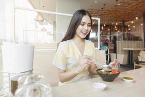 mulher está comendo em restaurante com protocolo de distanciamento social enquanto cidade de bloqueio devido à pandemia de coronavírus foto