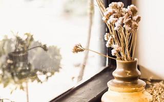 um pequeno vaso de plantas exibido na janela. buquê de flores perto da janela com cortina. estilo de vida para viver a ideia de casa foto