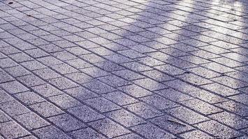 plano de fundo texturizado de pavimento de cidade velha. telhas de pavimentação na luz solar. sol na calçada