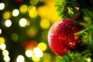 árvore de natal decorada no fundo de ano novo turva turva. enfeite de natal em fundo de madeira com flocos de neve, cartão de feliz natal e feliz ano novo. foto