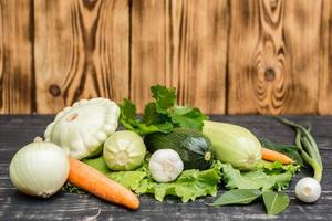 um conjunto de legumes em uma tábua de madeira foto