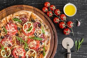 pizza italiana tradicional, legumes, ingredientes em um fundo escuro