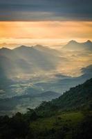 maravilhoso nascer do sol de manhã novo dia na montanha da colina com raios de sol brilhando no céu de nuvens foto