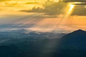 paisagem maravilhosa nascer do sol de manhã novo dia na montanha da colina com raios de sol brilhando no céu de nuvens foto