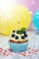 cupcake com uma vela numeral três foto