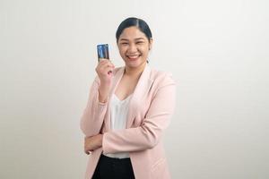 mulher asiática segurando um cartão de crédito com fundo branco foto