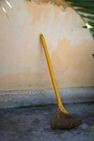 vassoura asiática tradicional com uma vara amarela. ao ar livre, perto de uma parede, sem pessoas. Vietnã foto