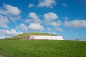 Newgrange passagem túmulo, um patrimônio mundial da unesco. uma das mais antigas câmaras funerárias neolíticas da Europa. céu azul com algumas nuvens. foto