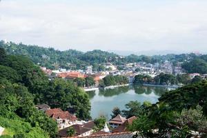 vista aérea de kandy, uma bela cidade no sri lanka com edifícios, um lago e muitas árvores. foto