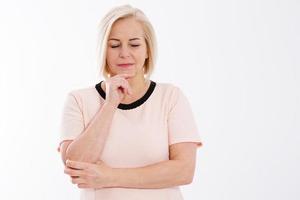 triste mulher de meia-idade pensativa posando em um fundo branco, conceito de saúde da menopausa foto