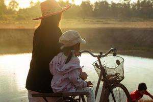 mãe e filha no campo ao pôr do sol foto