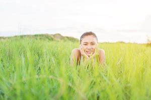 mulher jovem e bonita, mulher sorridente saudável relaxante na grama verde em prados. foto