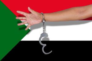 algemas com a mão na bandeira do sudão foto