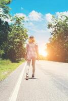 mulher jovem hippie indo embora na estrada lateral sozinha. foto