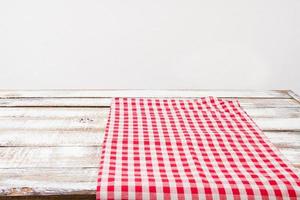 toalha de mesa quadriculada na velha mesa de madeira, conceito de férias foto