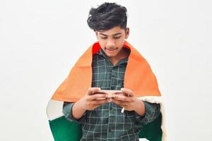 jovem indiano comemorando o dia da independência ou dia da república e usando smartphone foto