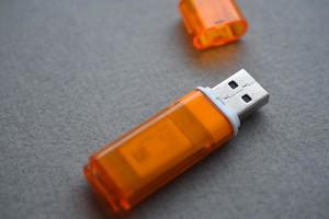 cartão flash usb laranja em fundo cinza foto