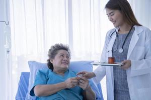 médica consolando paciente idosa no hospital foto