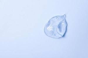 gel transparente grosso, cosméticos. textura de sabão, anti-séptico, esfregaço de hialuron na vista superior azul foto