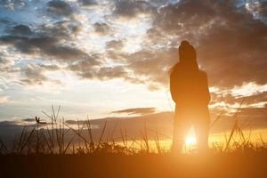 silhueta de mulher em campo durante o pôr do sol. foto