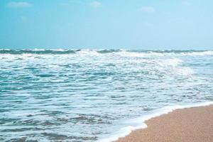 onda suave com bolha do oceano azul na areia branca na praia tropical na temporada de verão. fundo de praia simples para o verão. onda azul bolha do mar à areia na praia. fundo de verão.