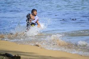 sorong, papua oeste, 12 de dezembro de 2021. uma família se divertindo na praia