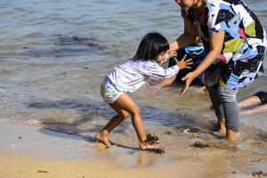 sorong, papua oeste, 12 de dezembro de 2021. uma família se divertindo na praia