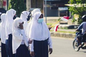 sorong, papua ocidental, indonésia, 4 de outubro de 2021. visita de estado do presidente da indonésia, joko widodo. crianças em idade escolar e professores saudaram a chegada do presidente da beira da estrada.