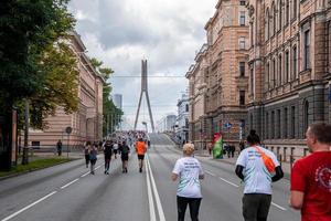 corredores atravessando as ruas de riga durante a maratona de tet riga. foto