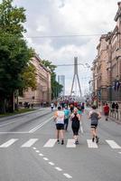 corredores atravessando as ruas de riga durante a maratona de tet riga. foto