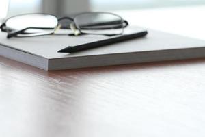 close-up do bloco de notas em branco com lápis na mesa de madeira do escritório foto