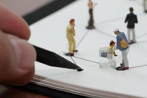 close-up de pessoas em miniatura com diagrama de rede social no notebook aberto na mesa de madeira como conceito de mídia social foto